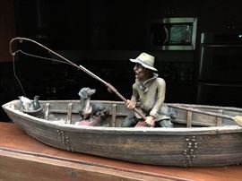 Little guy in boat, fishing with his dog. Tiny bucket of fish on board