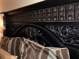 Headboard displaying ornate carved design.