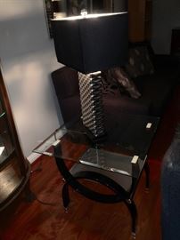 Contemporary glass top end table and silver lamp.