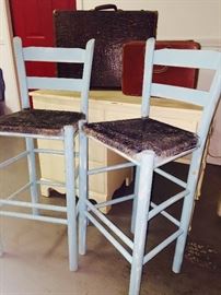 Distressed blue bar stools, vintage desk, and suitcases