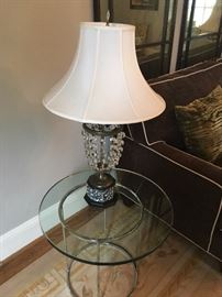 A pair of thick bevel glass tables with crystal lamps
