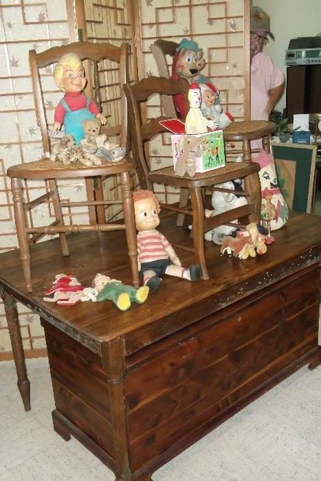 Handcrafted solid wood table with a handcrafted cedar chest.  The vintage chairs are filled with authentic collection of toys from the 50's and 60's.  Notice the wooden room divider screen backed with decorative paper featuring a leaf motif.