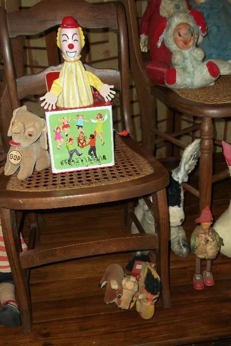 Vintage pop-goes-the-weasel toy sitting on a vintage oak and cane chair.