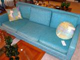 Vintage couch accented with vintage pillows and surrounded by mid-century home decor.