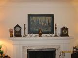 Mantle decorated with vintage clocks, crystal, brass, and vintage oil painting.