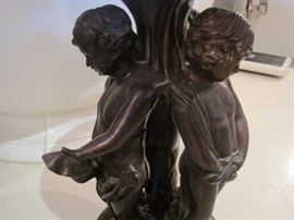 Bronze pedestal table with three central Putti.