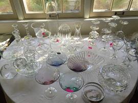 Variety of glassware, including colored polka-dot Waterford martini glasses, Riedel decanter, Kosta Boda, vintage crystal, crystal wine glasses.