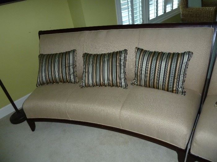 Matching Beige curved armless sofa/couch with dark wood accents