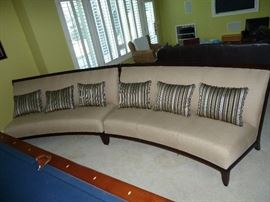 Matching Beige curved armless sofa/couch with dark wood accents