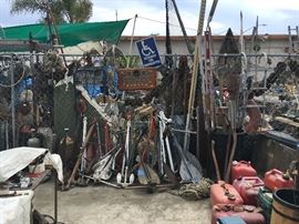 Swap meet area with variety of mixed items, anchors, gasoline cans, plastic and metal
