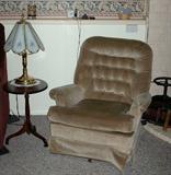 Tan upholstered swivel rocker and mahogany lamp table.