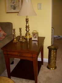One of a pair of lamp tables displaying brass items.  Brass umbrella holder