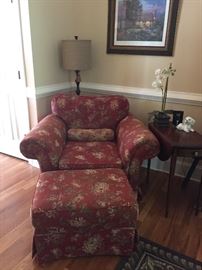 Overstuffed chair, ottoman, lamp and antique side table.
