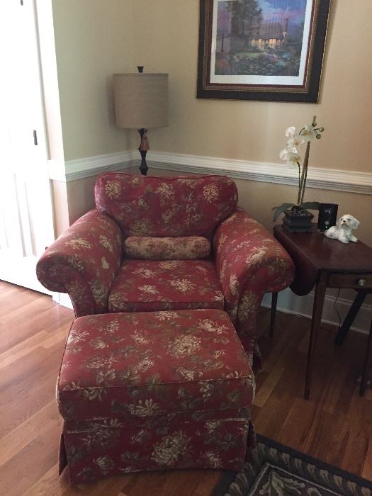 Overstuffed chair, ottoman, lamp and antique side table.