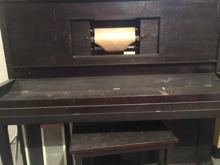 Antique player piano with rolls of music