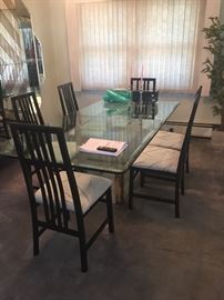 solid glass dining table and 6 black chairs.. table is approx. 7' long x 3.5' wide