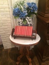 Marble top antique table; book shelf with great red shelf-filler books