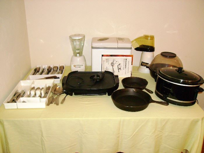 Kitchen appliances, cast iron frying pans, and utensils