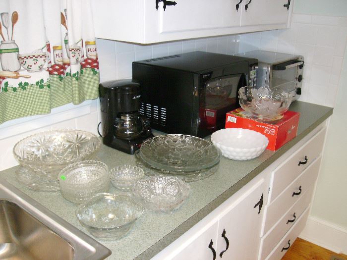 Glass serving dishes and bowls.  Microwave, toaster oven and coffee maker.