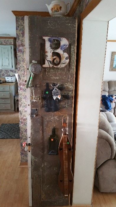 Side of cabinet made from reclaimed doors with dulcimer, corkscrew and decor
