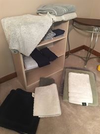 Large assortment of bathroom and throw rugs, towels, and mats.