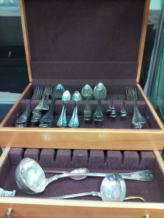 We estimate this continental silver plate service as dating back to the 19th century. The case of 70 pieces includes 2 ladles, 1 sugar spoon, 12 large forks, 11 forks, 11 small forks, 11 soup spoons, 10 large serving spoons, and 12 small spoons. 