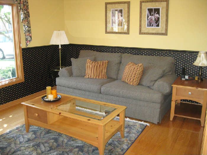 Nice gray sofa and light oak tablesl