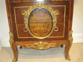 Two drawers in bottom of ornate lighted curio cabinet with painted scene 