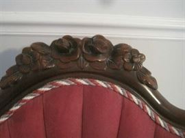 Carving at top of Victorian chairs with red, green and white braid trim