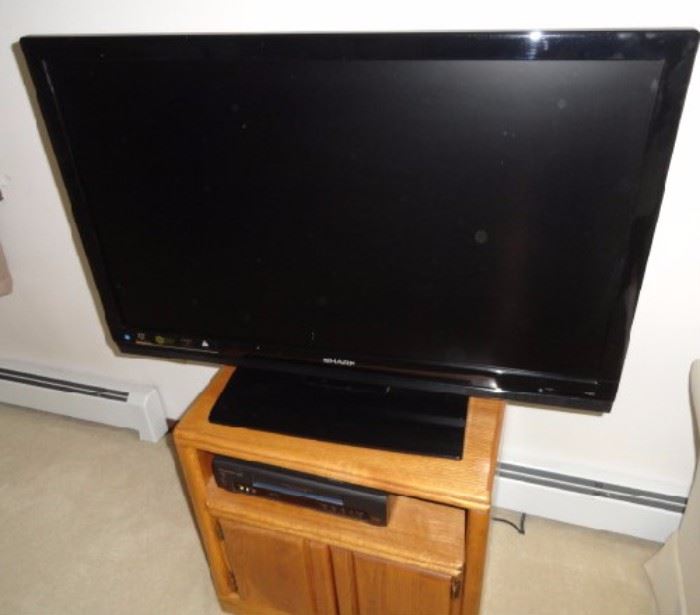 "FLAT SCREEN TV WITH EXTRAS!" -TV stand: one cabinent, one cubby: 24 1/2"W x 17"D x 25"H -42 in Sharp TV: Full HD, 1080P, HDMI x 3, Spectral contrast engine, Dolby Digital -Panasonic VCR Plus+
-Memorex DVD player: Progressive scan, Component, S-Video output