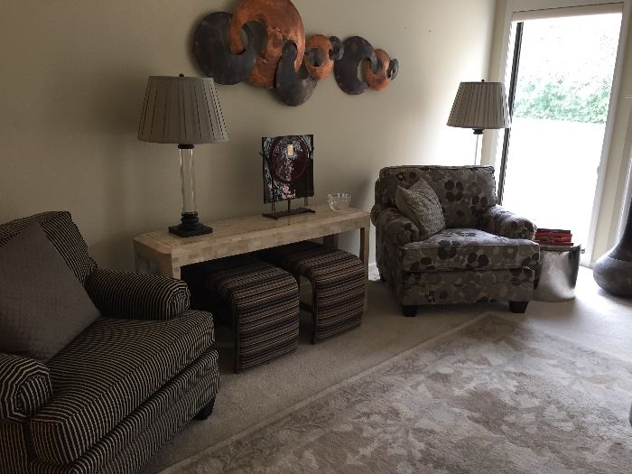 Arm chairs, stone sofa table, benches, Pottery Barn Wool area rug, lucite table and floor lamps, and metal artwork
