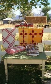 Painted primitive pine table, cotton quilts, and decorating books
