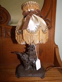 Close-up of small metal elephant with pagoda boudoir lamp