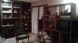 books, sitting room chairs, entertainment system, glass top table, plenty of knickknacks