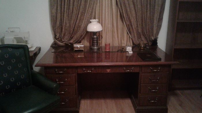 wooden office desk, cushioned office chair, desk lamp, office supplies