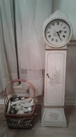 white wooden floor clock, wooden basket with artificial fruit 