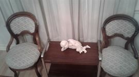 2 sitting cushioned sitting chairs, wooden table, angel figurine 