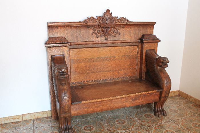 Oak hall seat:  Exceptional American Victorian-era carved golden oak hall seat with griffin arms and claw feet.
