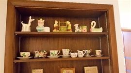 Shawnee, McCoy, and various planters from the pottery era.  Tea cups with saucers from Japan, Germany, etc.  Small prints and hand stitched decor'.