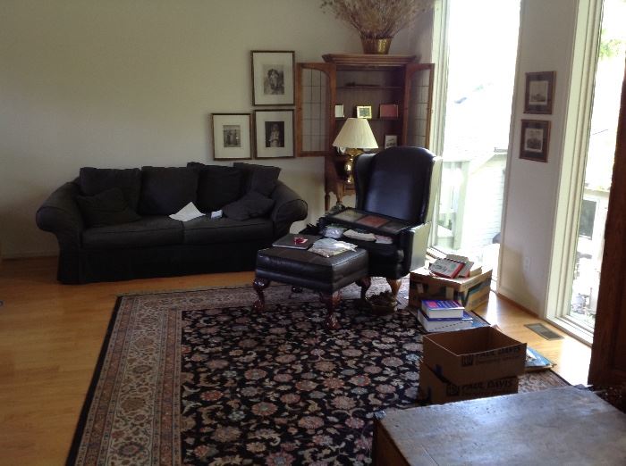 long shot of the living room with one of the matching sofa/loveseat pair, one of the black leather wings, et
