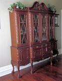 Fascinating two piece antique reproduction Chippendale breakfront china cabinet. Four drawers and four doors in bottom piece; Four glass doors with beautiful fretwork; Approximately 8 feet tall at the highest point, 81" wide, 20" at center.
