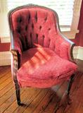 One of two French, upholstered arm chairs; heavily carved arms and back.