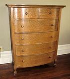 Antique oak bow front chest with paw feet.