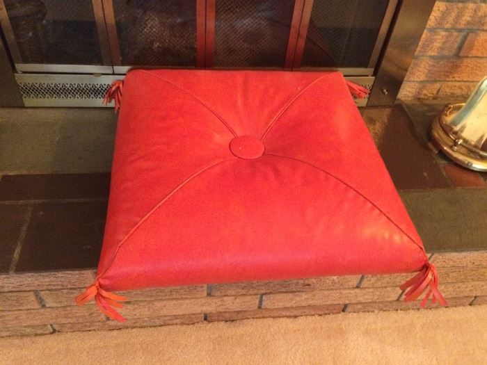 red leather pouf with tassels