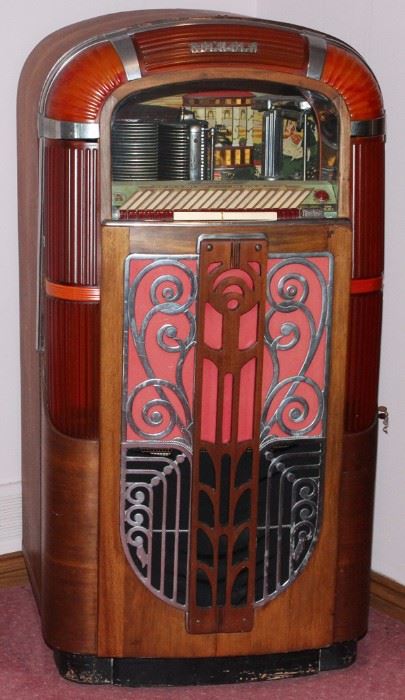 Lot#22, RMC ROCK-OLA JUKEBOX, C.1945, H 58", W 31", D 25"Molded plastic and mahogany case with push buttons along the top, offering a selection of twenty.