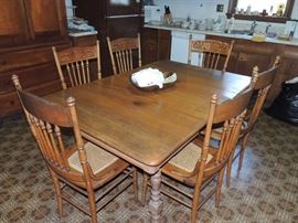 antique oak table with six leaves and six pressed back oak chairs