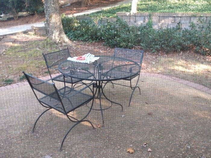 Lovely wrought iron outdoor dining set. Ol' uncle Billy got drunk one night and rolled down the driveway, never to be seen again.                                                                      IF you're wondering what happened to the fourth chair... AND, what about my "film noir" photo talent, shooting this cozy vignette through a screen?!?