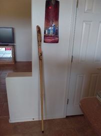 carved walking stick and painted wall sconce.