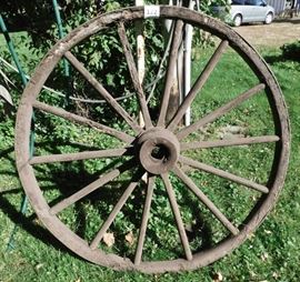 large antique wooden wagon wheel with metal rim