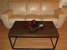 Embossed Brass Top Table on Black Metal Box Framed Base Made in India (42"W X 24"D X 18"H) shown in front of a Ivory Leather Sofa